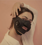 InstaLift EMS Mask worn by a model, hand resting on her head