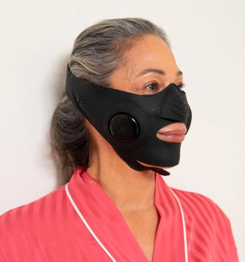 InstaLift EMS Mask on a silver-haired model in a pink robe, profile view
