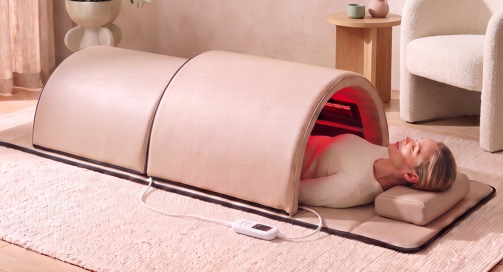 The Restore Dome™ full-body infrared sauna in a bright living room, head resting outside the larger dome section